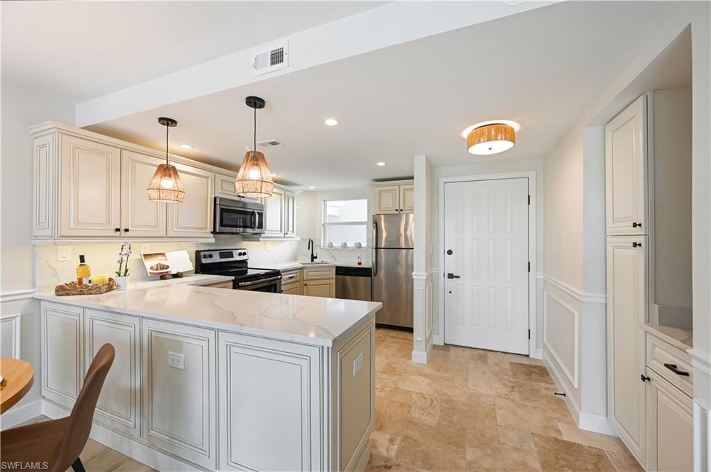 190 Pebble Beach Boulevard, Unit 202 Naples, FL 34113 - Photo 8 of 36 a kitchen with stainless steel appliances a refrigerator sink and cabinets