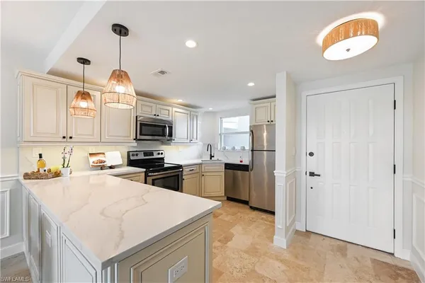 a kitchen with stainless steel appliances granite countertop a sink a stove and a refrigerator