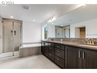 17127 Southwest Kalapuya Lane Sherwood, OR 97140 - Photo 11 of 18 a bathroom with a granite countertop sink a large mirror and a bathtub