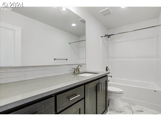 17127 Southwest Kalapuya Lane Sherwood, OR 97140 - Photo 12 of 18 a bathroom with a granite countertop sink a toilet a shower and a mirror
