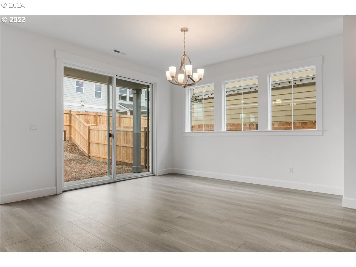 17127 Southwest Kalapuya Lane Sherwood, OR 97140 - Photo 4 of 18 an empty room with wooden floor and windows