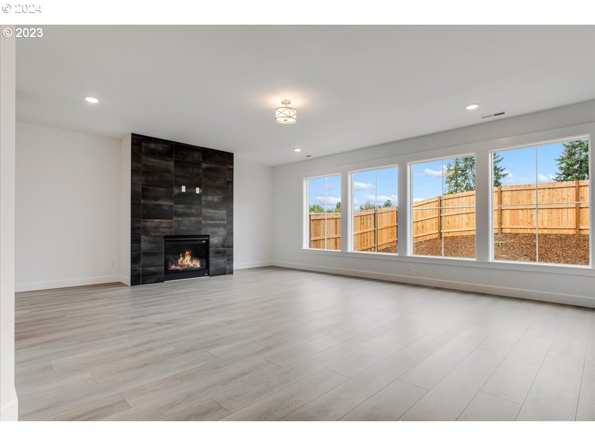 17127 Southwest Kalapuya Lane Sherwood, OR 97140 - Photo 6 of 18 a view of an empty room with wooden floor and a window