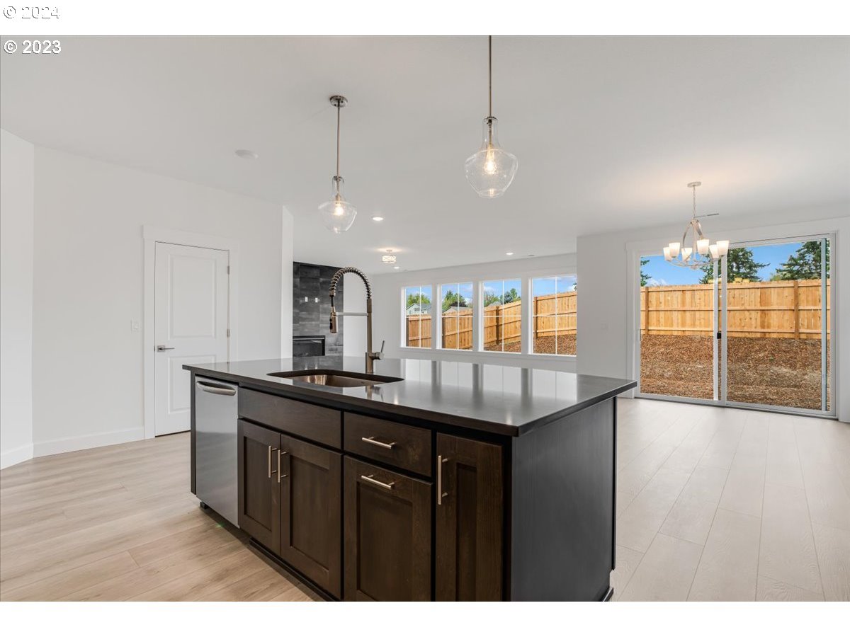 17127 Southwest Kalapuya Lane Sherwood, OR 97140 - Photo 7 of 18 a kitchen with stainless steel appliances granite countertop a sink stove and wooden floor