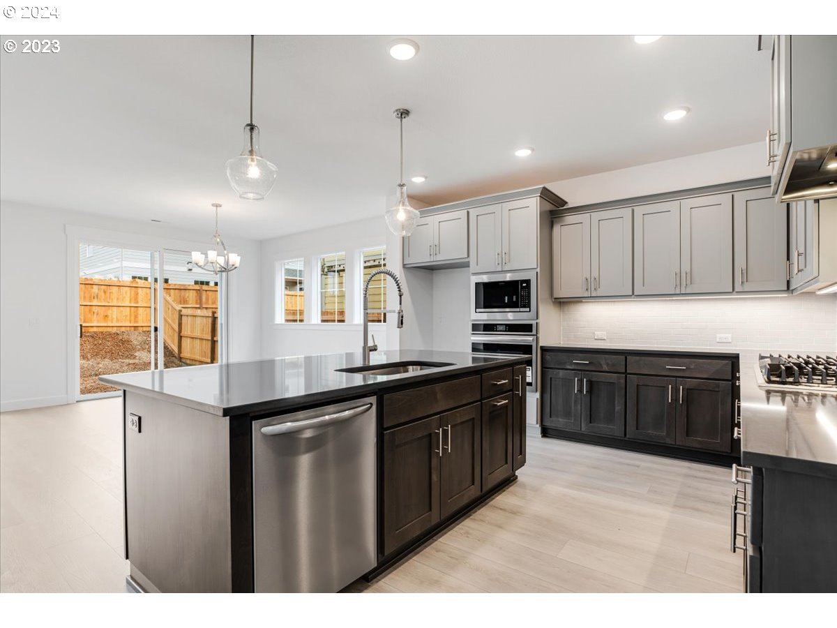 17127 Southwest Kalapuya Lane Sherwood, OR 97140 - Photo 9 of 18 a kitchen with stainless steel appliances granite countertop a sink a stove and a refrigerator