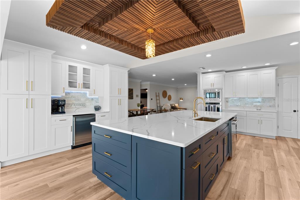 3300 Floramar Terrace New Port Richey, FL 34652 - Photo 28 of 75 a large kitchen with kitchen island a stove a sink dishwasher and a refrigerator with wooden floor