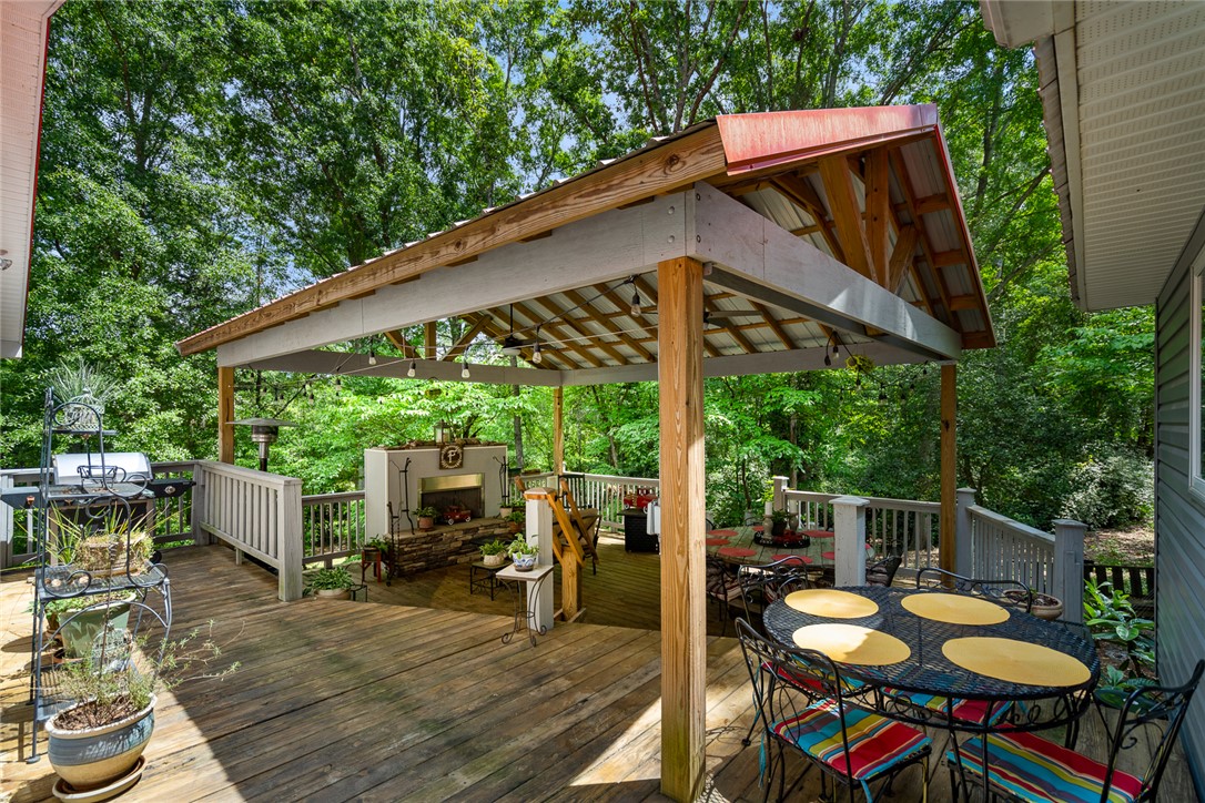 324 Hobson Road Anderson, SC 29621 - Photo 32 of 46 This spacious outdoor deck with a covered area and fireplace offers serene woodland views.