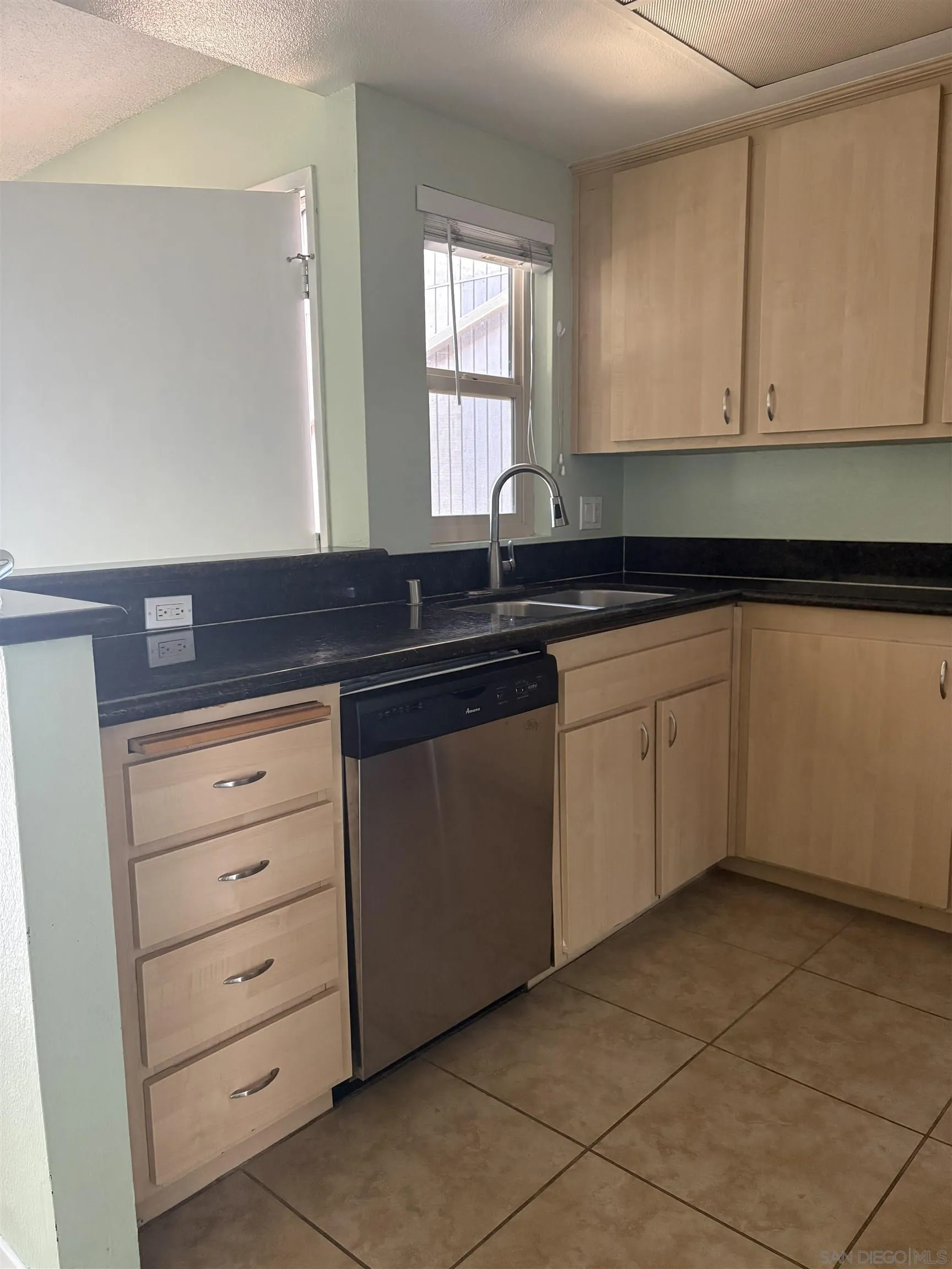 5962 Rancho Mission Road, Unit 222 San Diego, CA 92108 - Photo 17 of 42 a kitchen with cabinets and window