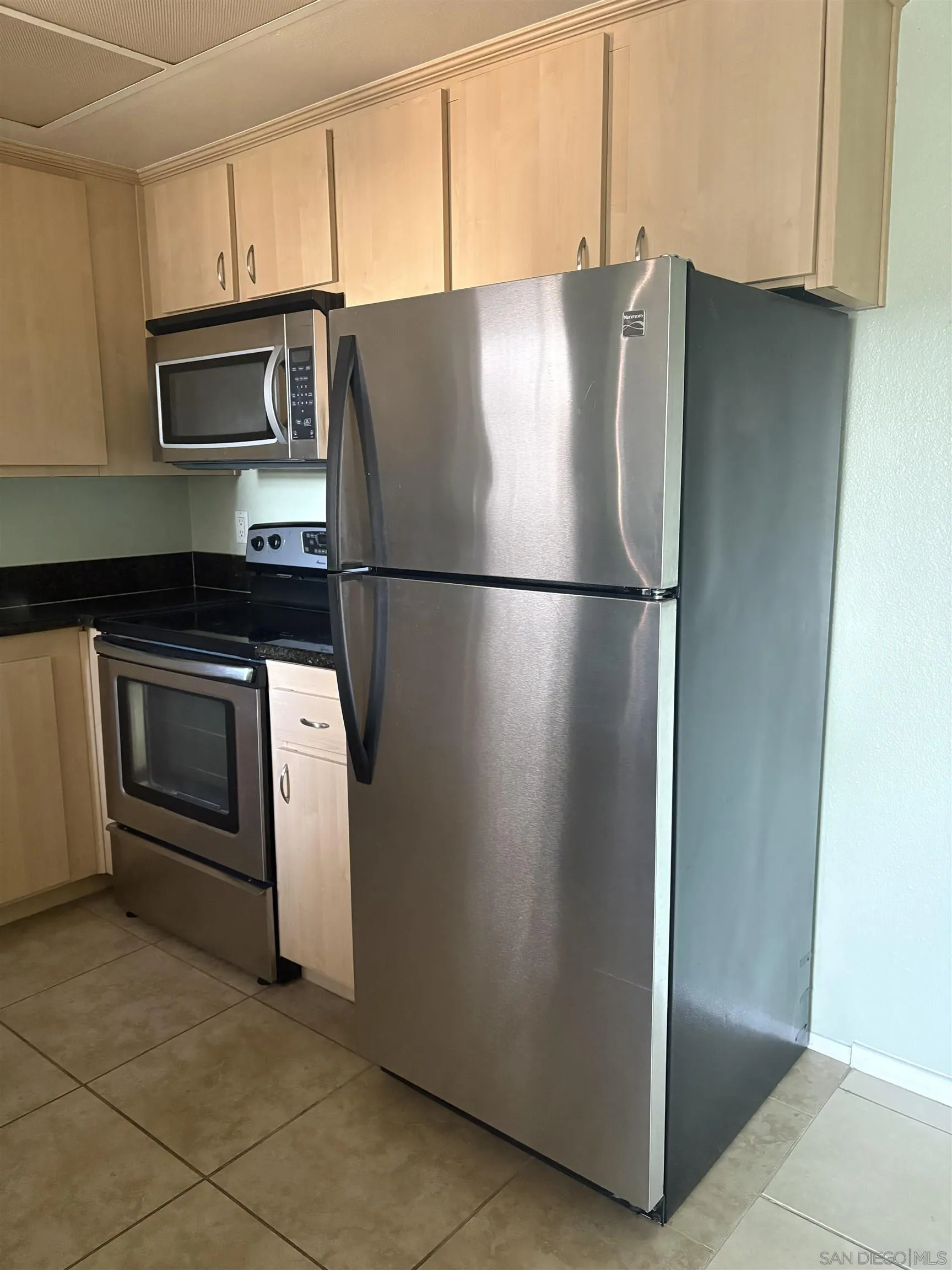 5962 Rancho Mission Road, Unit 222 San Diego, CA 92108 - Photo 20 of 42 a white refrigerator freezer and a stove sitting inside of a kitchen