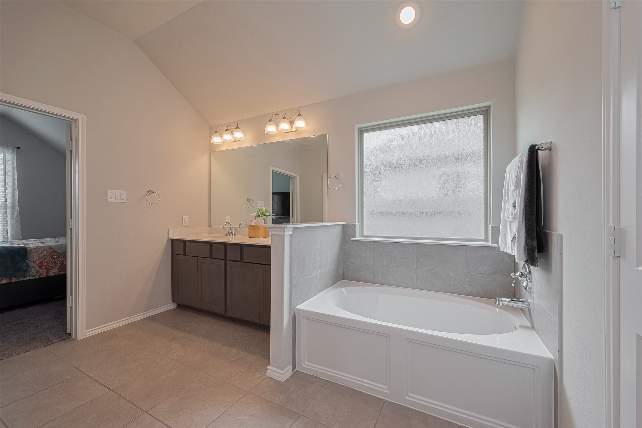 25446 Fossa Drive Tomball, TX 77375 - Photo 16 of 29 a bathroom with a tub a sink and a large mirror
