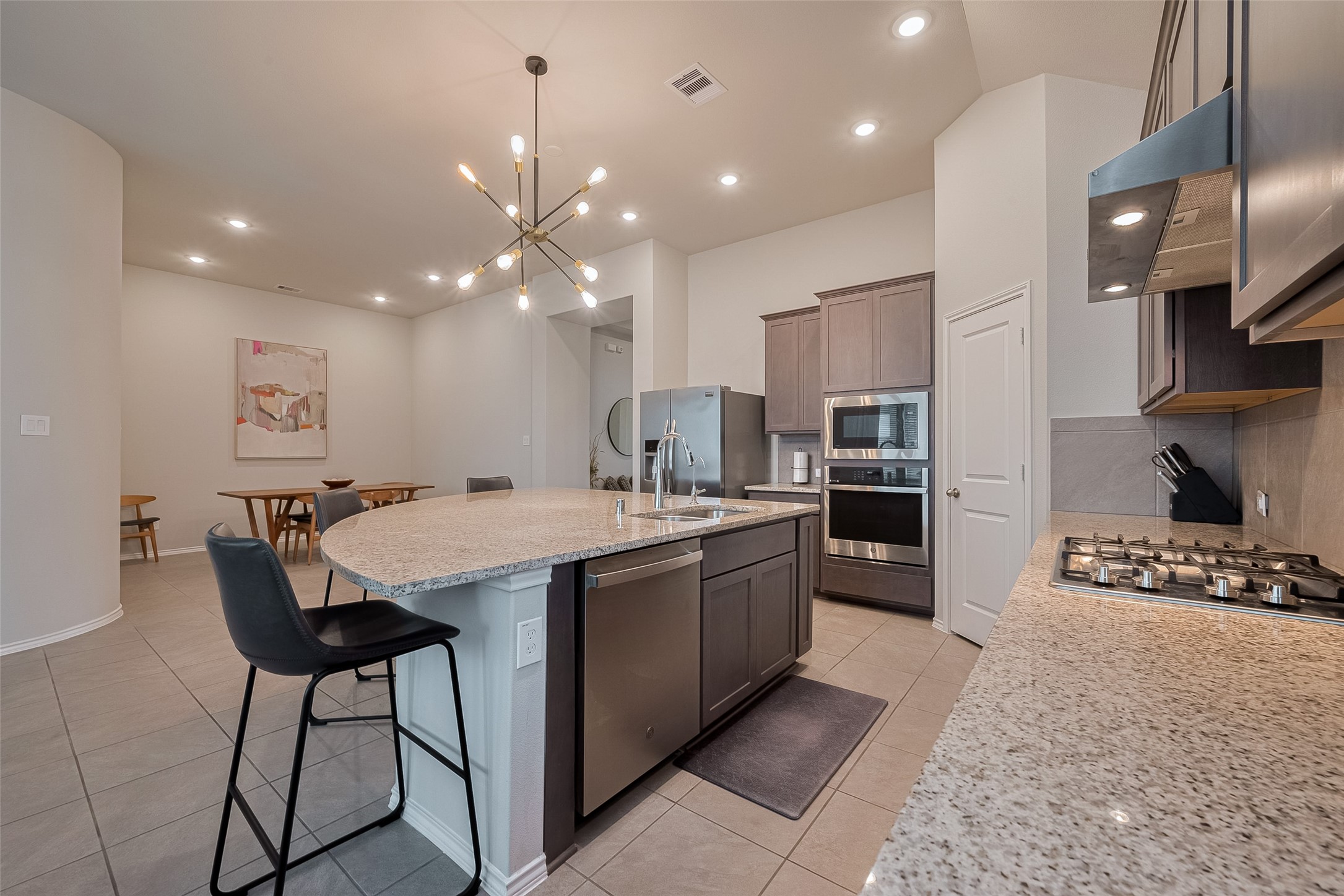 25446 Fossa Drive Tomball, TX 77375 - Photo 6 of 29 a kitchen with stainless steel appliances kitchen island granite countertop a sink and a refrigerator