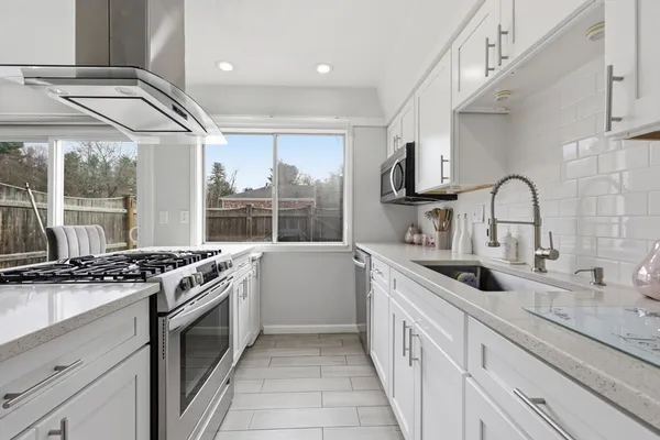 a kitchen with stainless steel appliances granite countertop a sink stove and cabinets