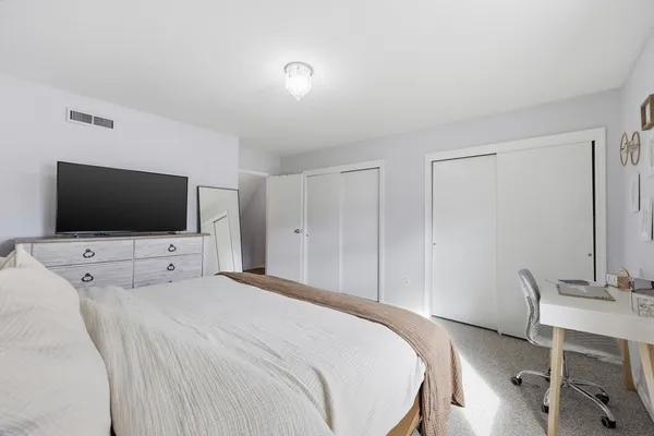 a bedroom with a flat screen tv and a bed