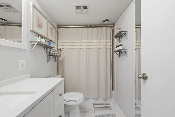 a bathroom with a shower a toilet and a sink