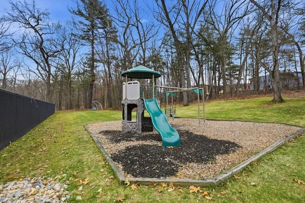 a view of backyard with wooden fence