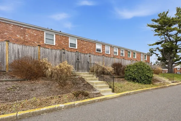 a front view of a house with a yard and trees
