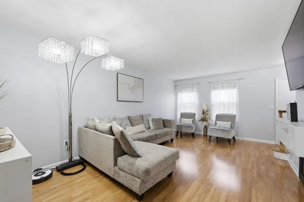 a living room with furniture or chandelier and a wooden floor