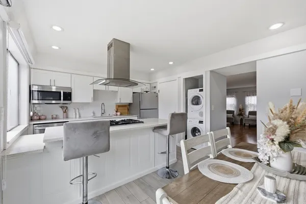 a large kitchen with stainless steel appliances kitchen island granite countertop a sink and cabinets