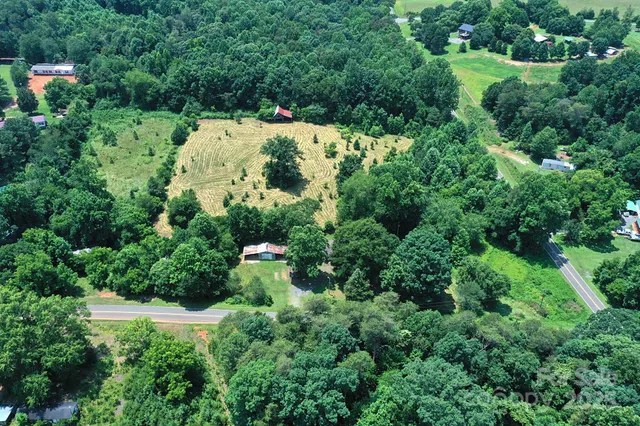 an aerial view of residential house with outdoor space and trees all around