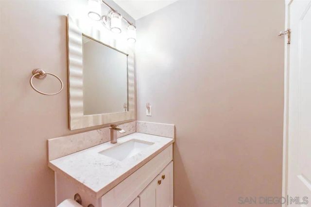 a bathroom with a granite countertop sink and a mirror