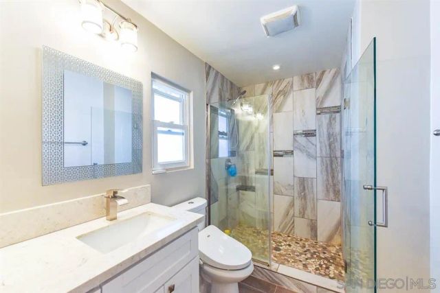 a bathroom with a sink a toilet and shower