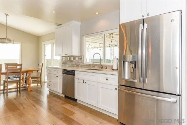 a kitchen with stainless steel appliances a refrigerator sink and cabinets