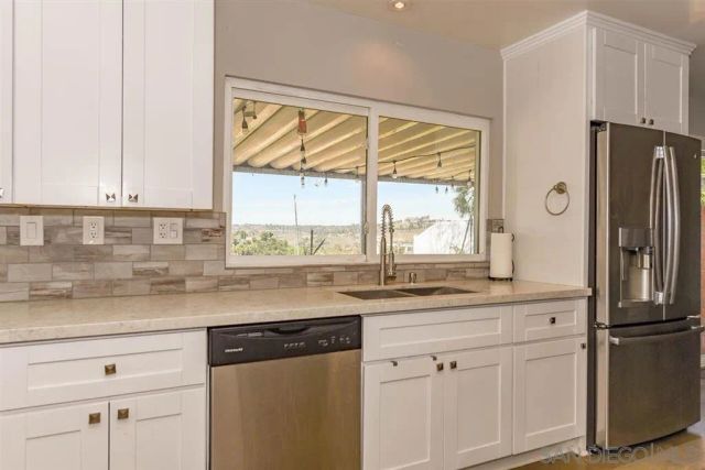 a kitchen with stainless steel appliances granite countertop a refrigerator and a sink