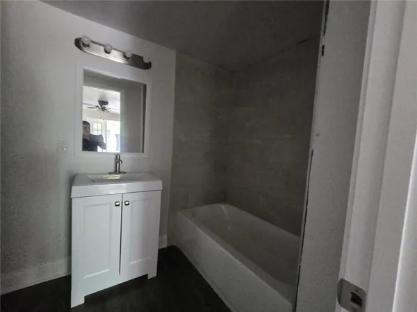 a bathroom with a bathtub a sink and a mirror