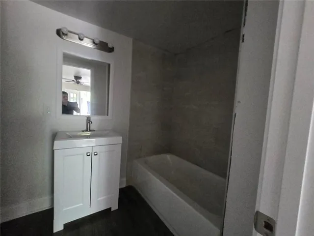 a bathroom with a bathtub a sink and a mirror