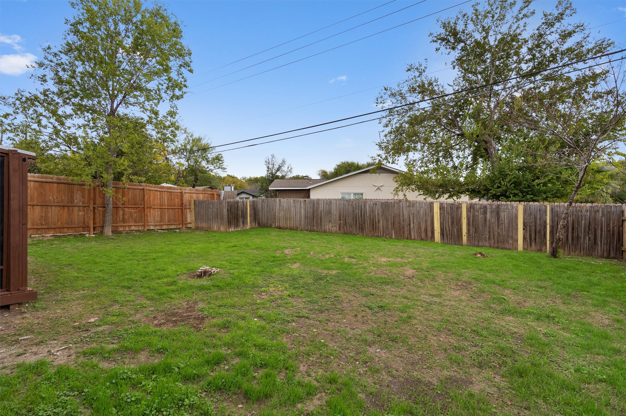 2532 Chaparral Trail Austin, TX 78744 - Photo 24 of 27 a view of a backyard with large trees and wooden fence
