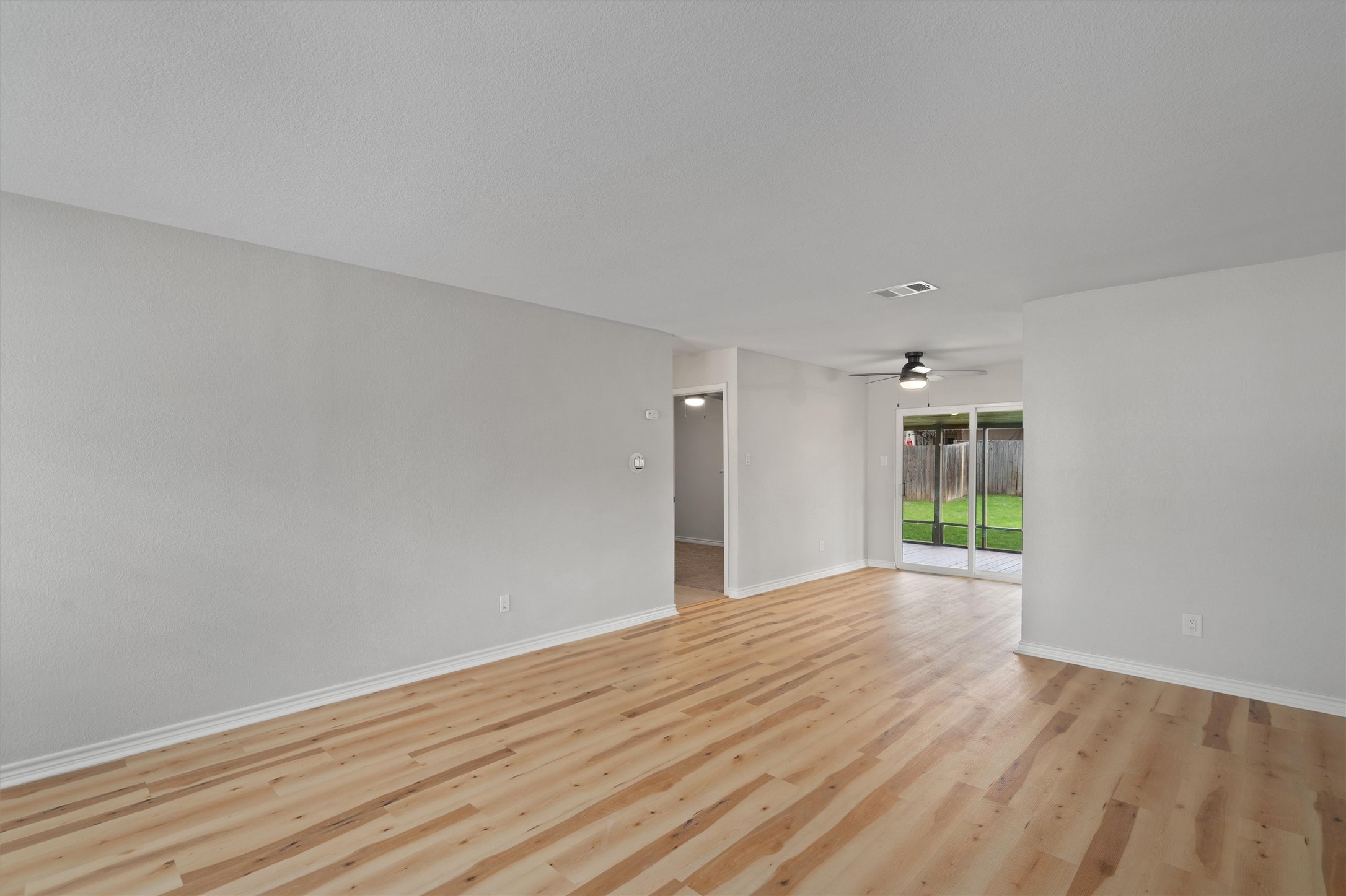 2532 Chaparral Trail Austin, TX 78744 - Photo 5 of 27 a view of an empty room with wooden floor and a window