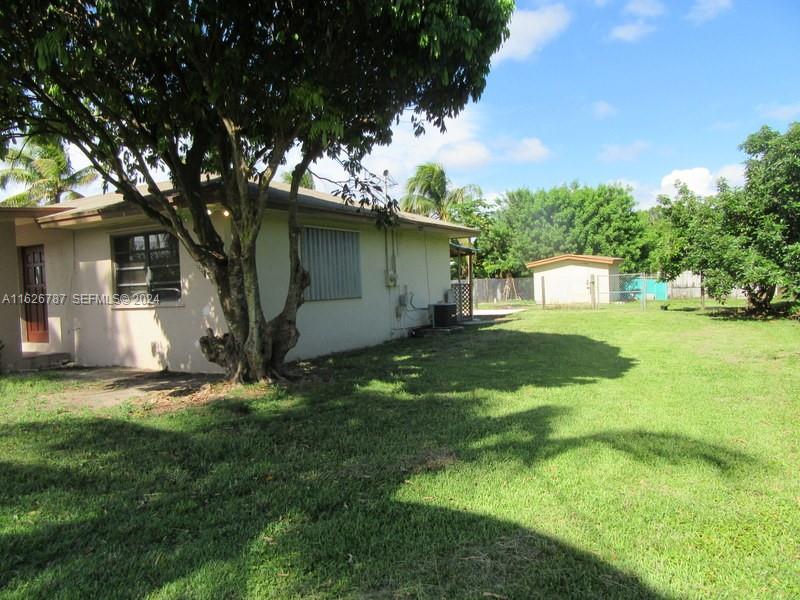 24925 Southwest 134th Court Homestead, FL 33032 - Photo 27 of 37 a view of a tree in front of a house with a big yard