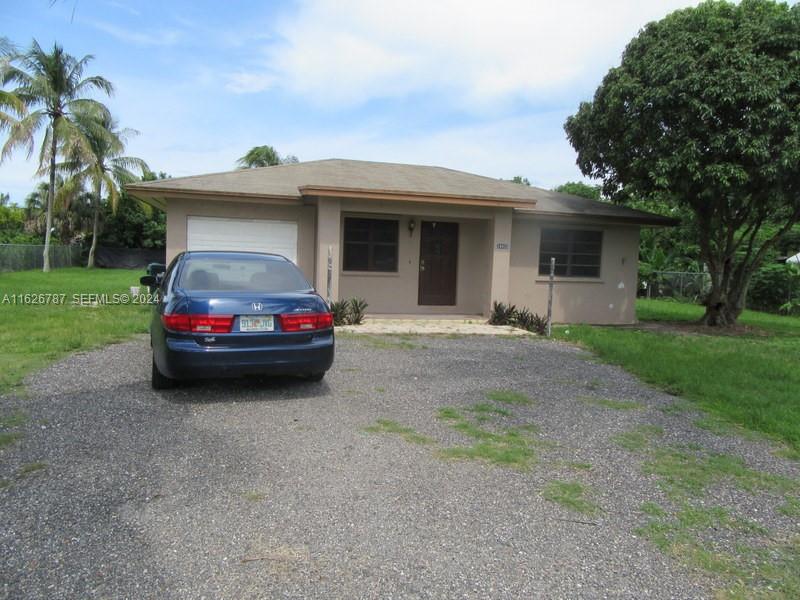 24925 Southwest 134th Court Homestead, FL 33032 - Photo 8 of 37 a car parked in front of a house and a yard