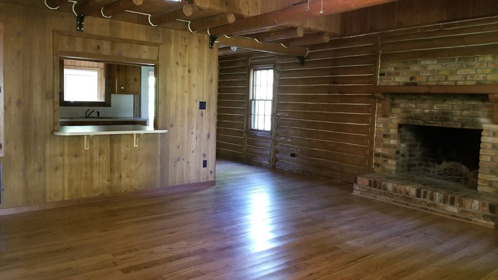 5212 Lick Skillet Road Hamilton, GA 31811 - Photo 3 of 17 a view of an empty room with wooden floor and a fireplace