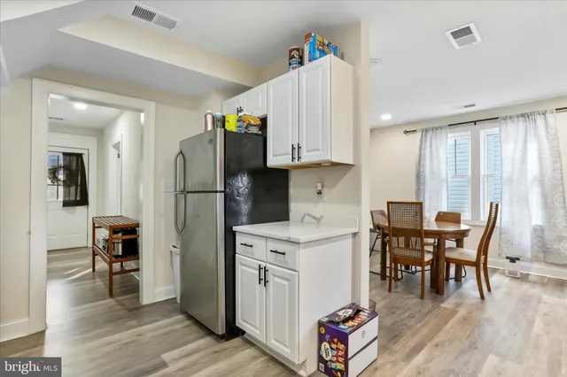 a kitchen with stainless steel appliances granite countertop a refrigerator and a dining table