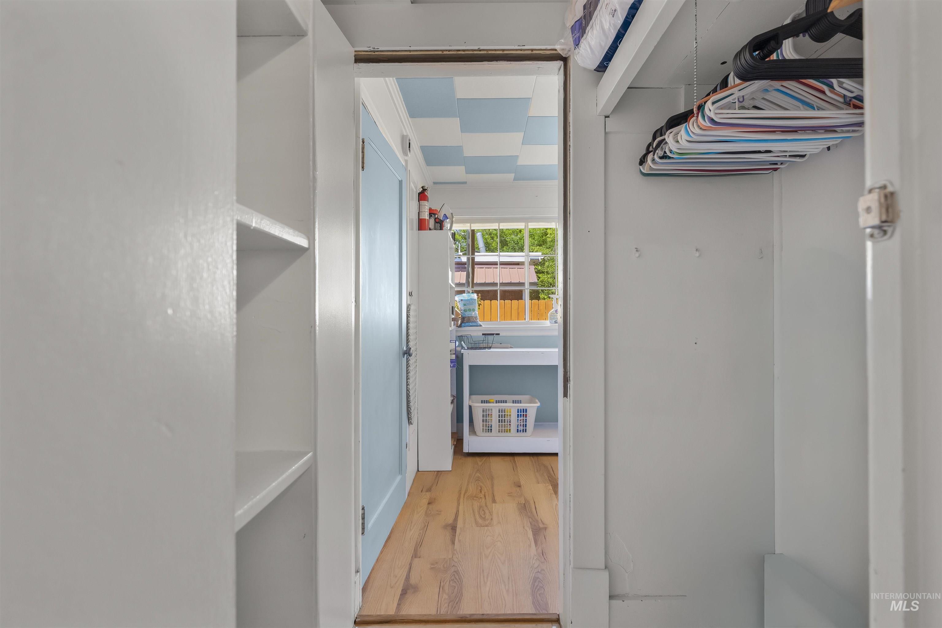 619 Prospect Avenue Lewiston, ID 83501 - Photo 22 of 37 Passage featuring built-in shelving, a clothes hanging rod, and wood-finish flooring