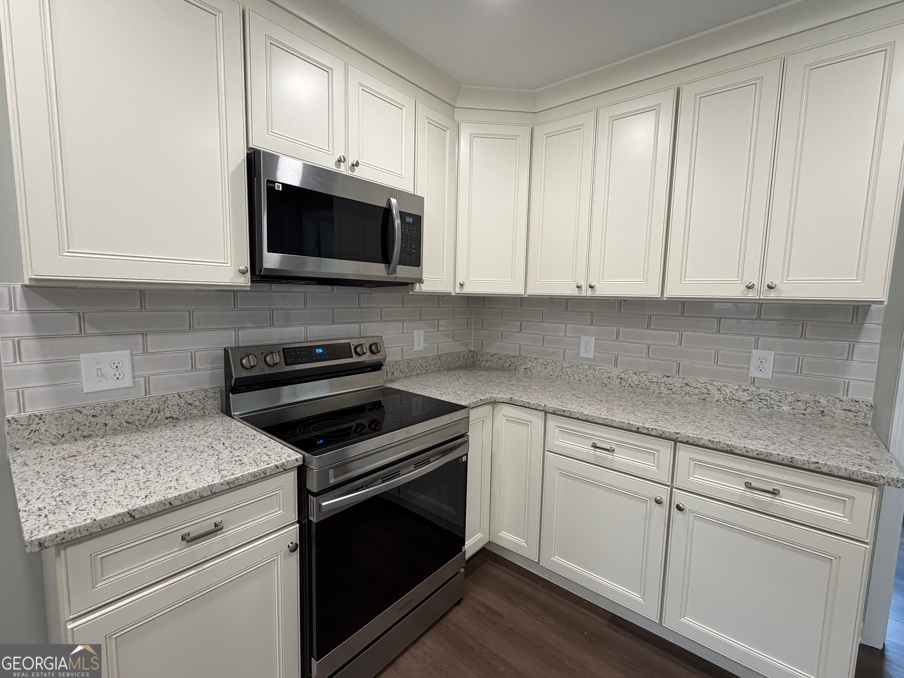 2809 Jones Road Sandersville, GA 31082 - Photo 11 of 31 a kitchen with white cabinets and stainless steel appliances