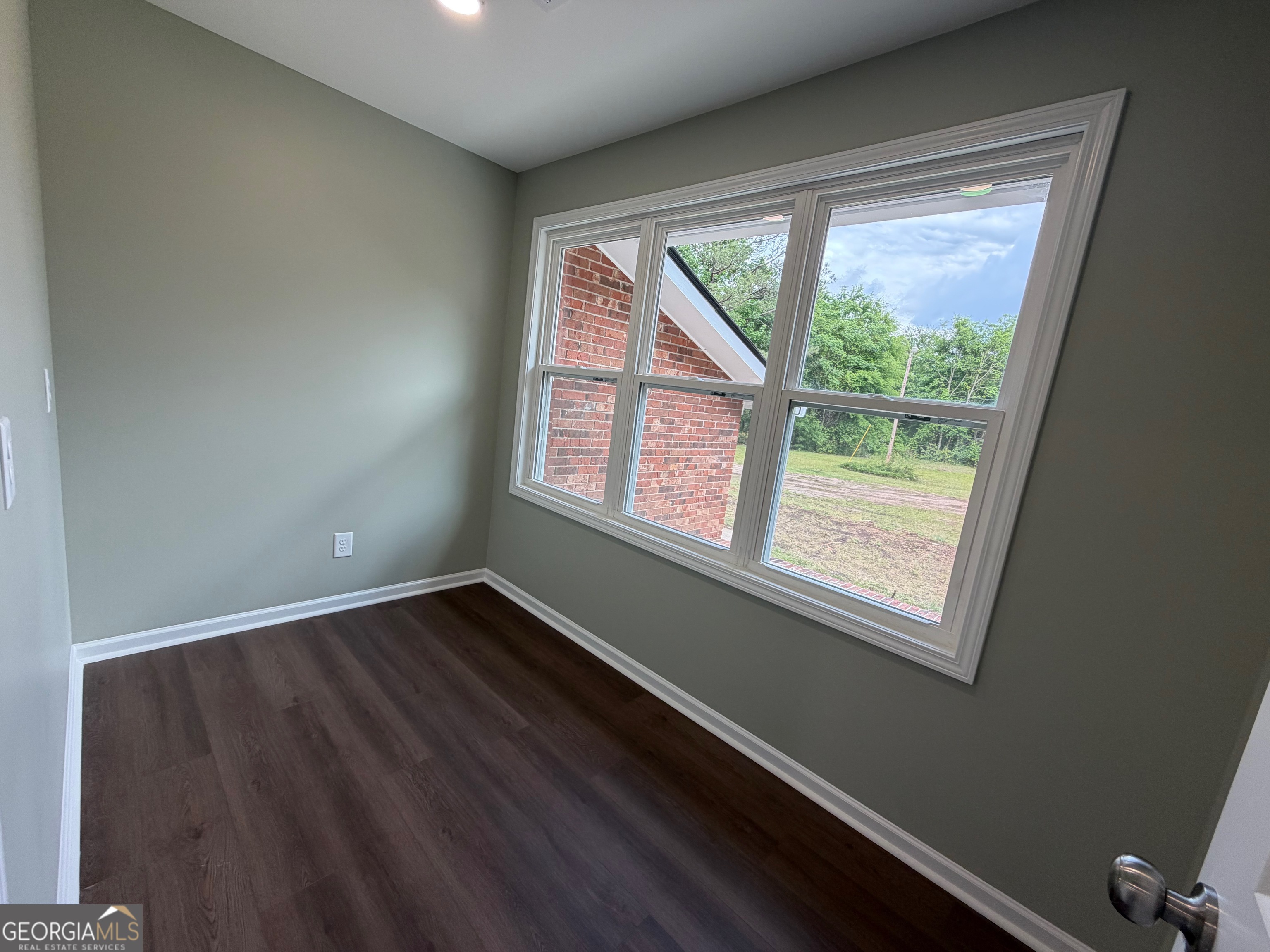 2809 Jones Road Sandersville, GA 31082 - Photo 12 of 31 a view of an empty room with wooden floor and a window