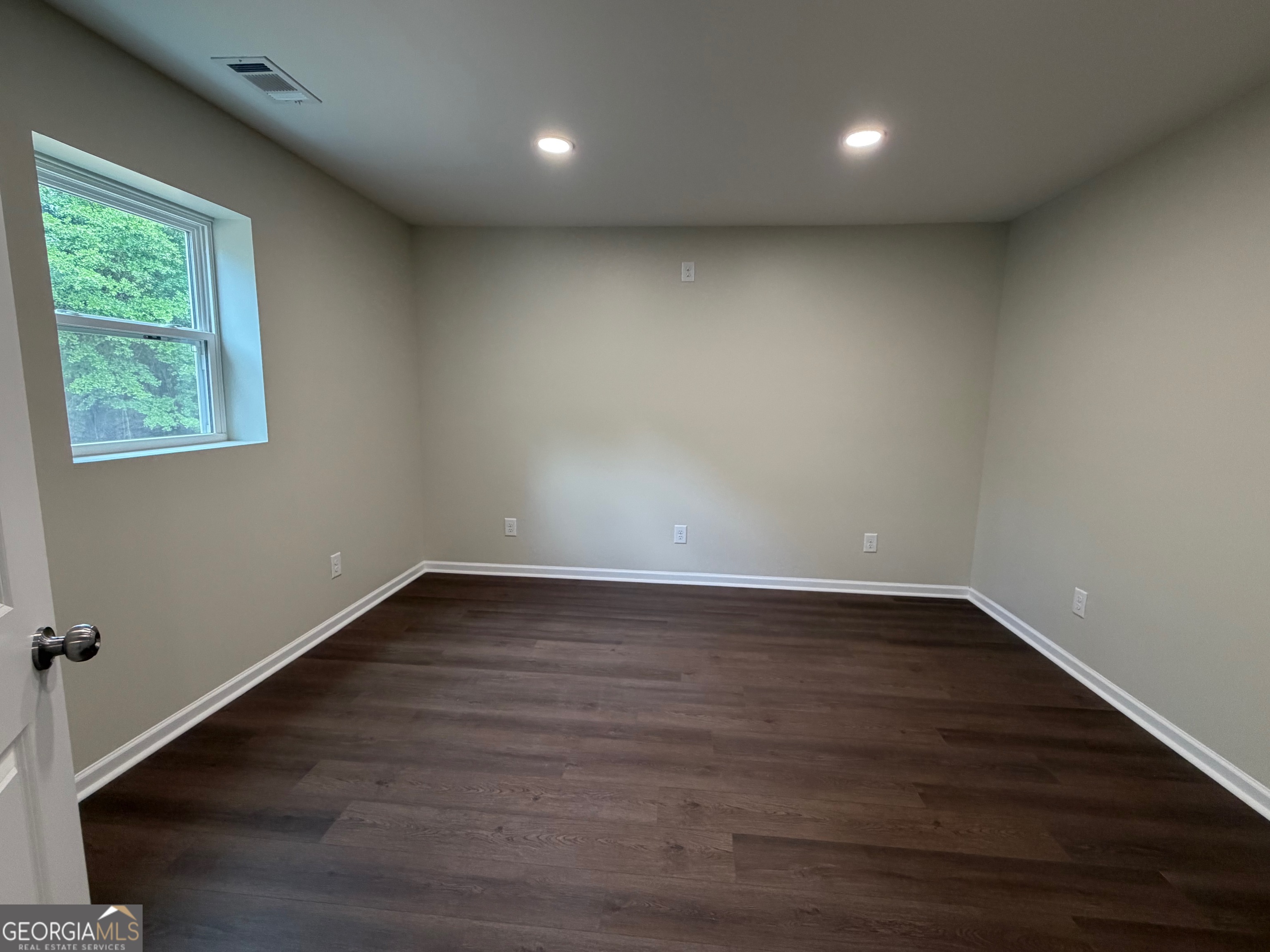 2809 Jones Road Sandersville, GA 31082 - Photo 15 of 31 an empty room with wooden floor and windows