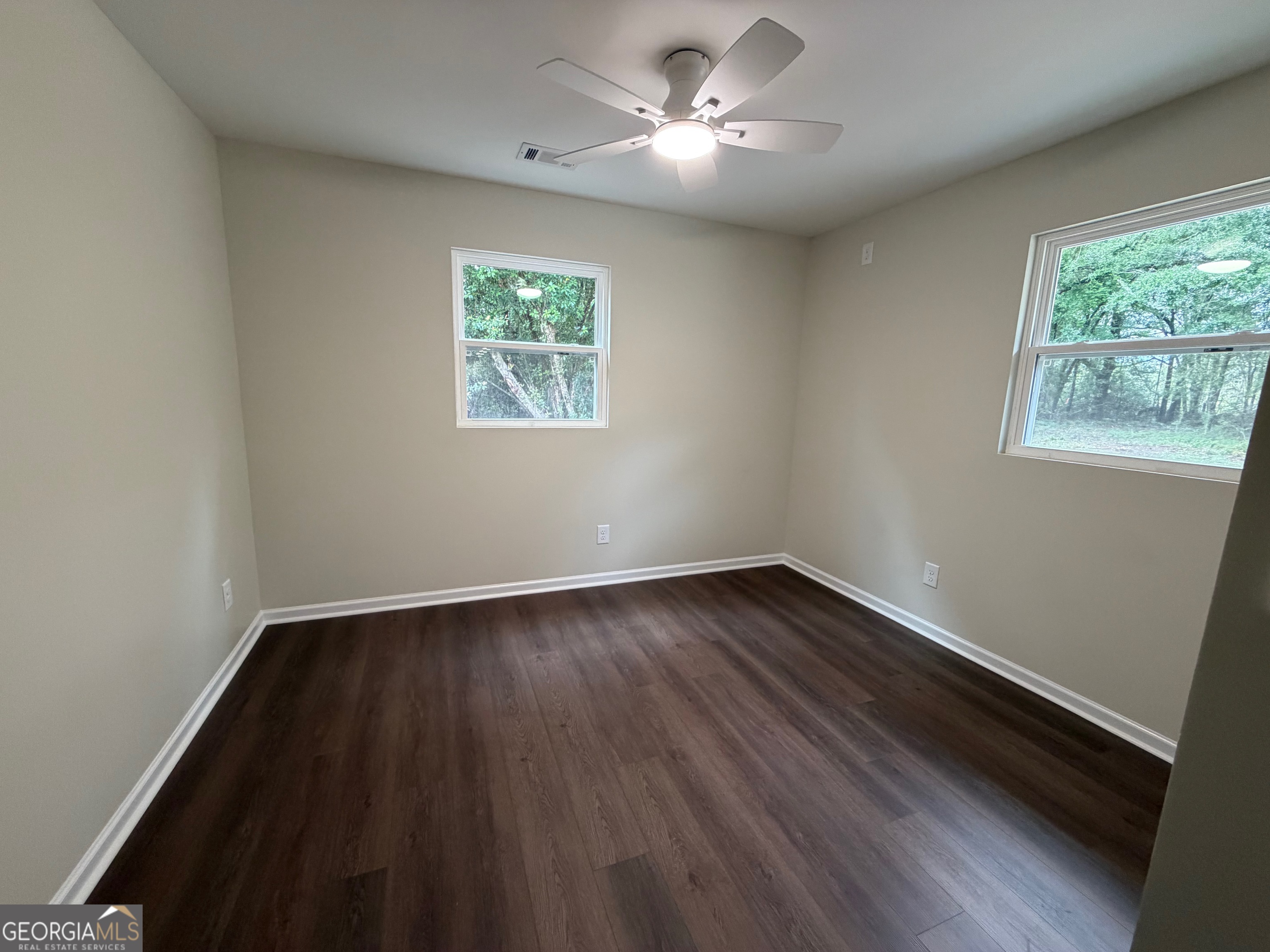 2809 Jones Road Sandersville, GA 31082 - Photo 21 of 31 a view of an empty room with wooden floor and a window