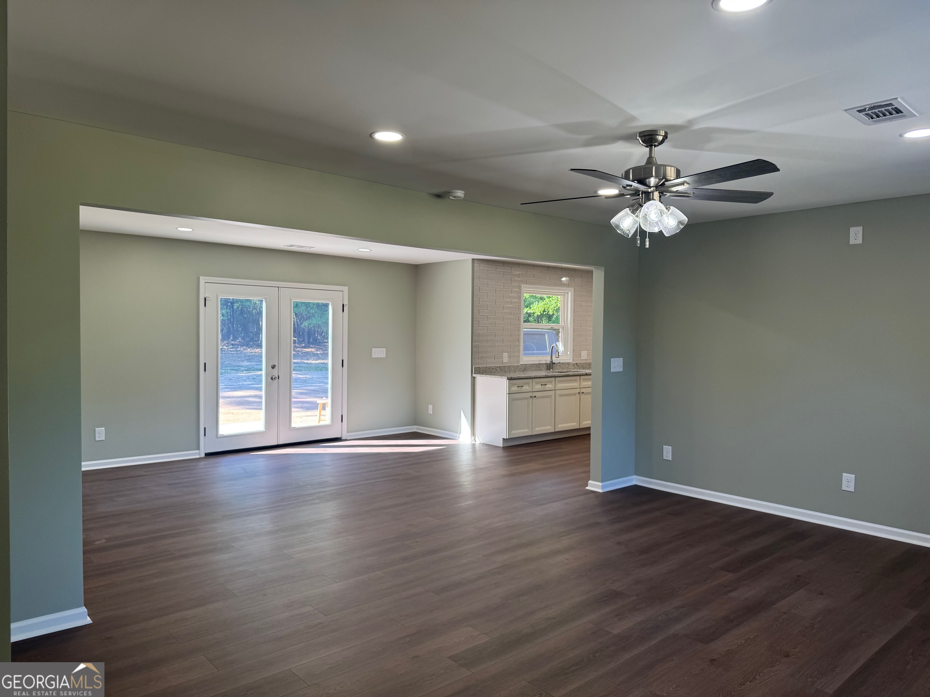 2809 Jones Road Sandersville, GA 31082 - Photo 7 of 31 a view of an empty room with window wooden floor and a ceiling fan