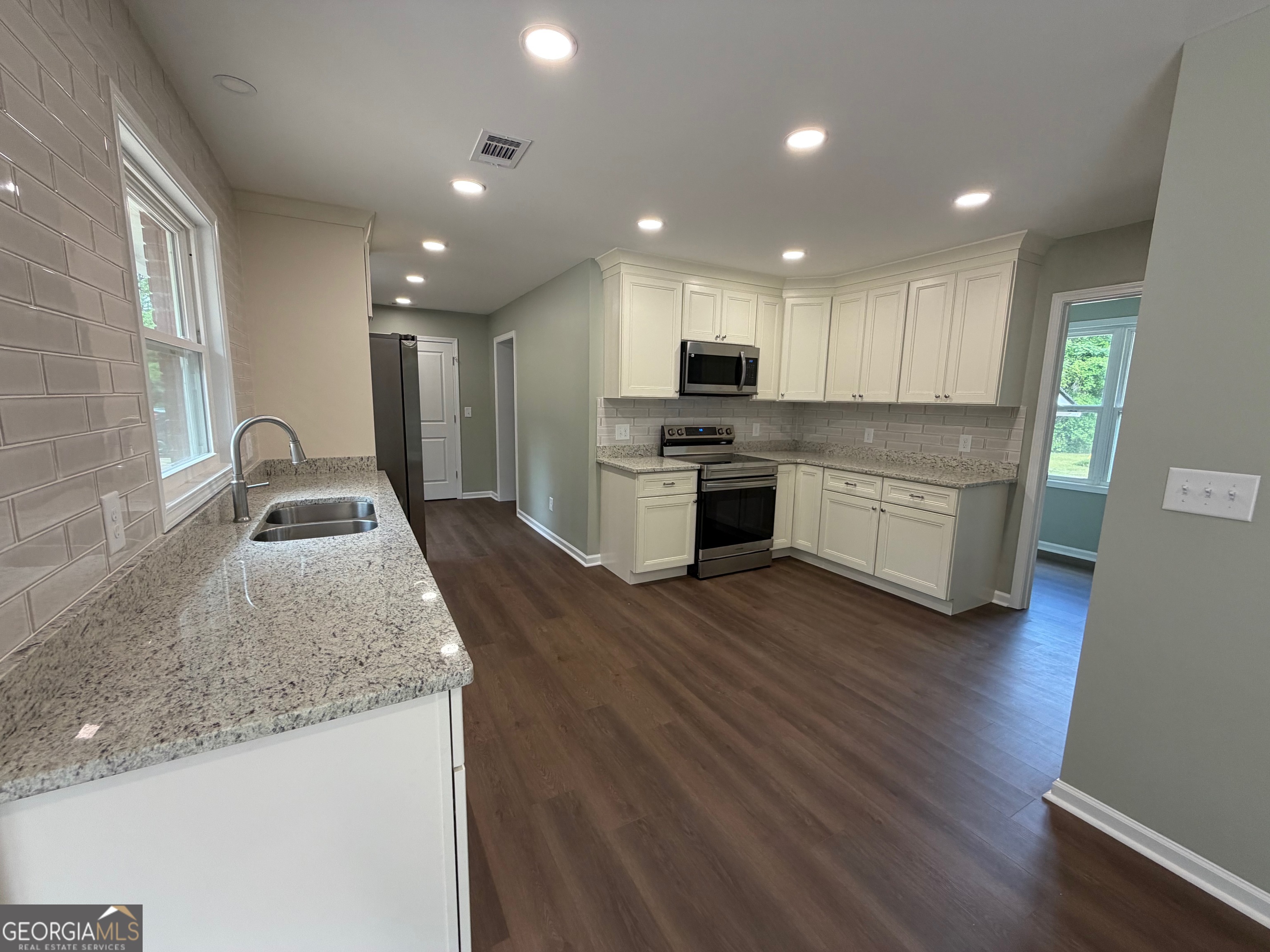 2809 Jones Road Sandersville, GA 31082 - Photo 8 of 31 a kitchen with stainless steel appliances granite countertop a sink a stove and a wooden floors