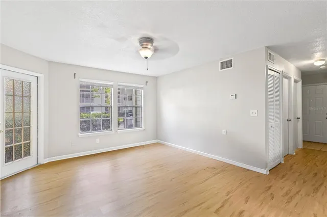 a view of an empty room with a window and wooden floor