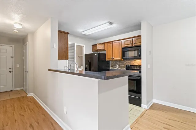 a kitchen with stainless steel appliances granite countertop a refrigerator and a stove top oven