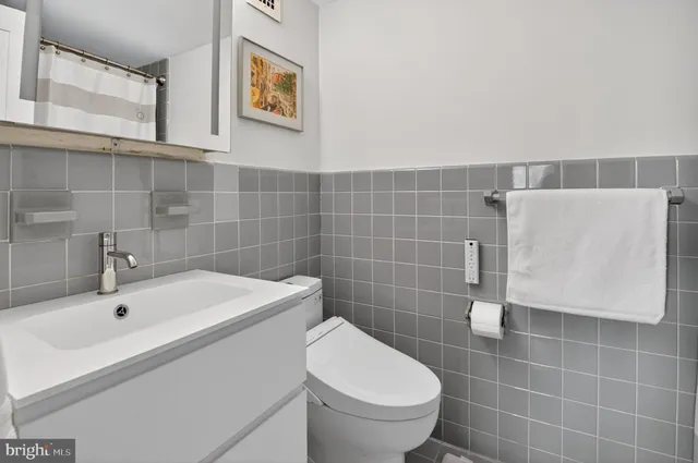 a bathroom with a sink a toilet and mirror