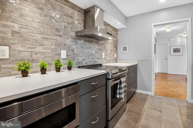 a kitchen with stainless steel appliances a sink stove and cabinets