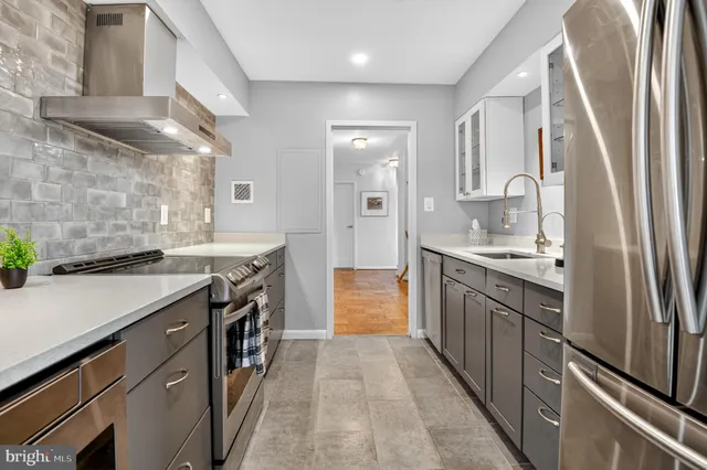 a kitchen with stainless steel appliances granite countertop a sink and a refrigerator