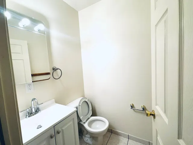 a bathroom with a granite countertop toilet and a sink