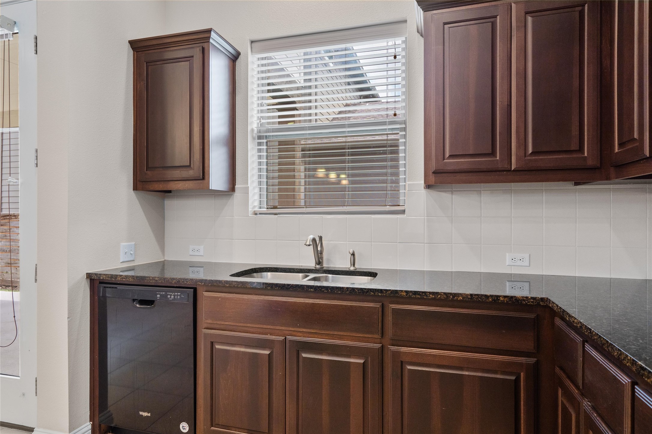 6907 Idea Road Austin, TX 78741 - Photo 8 of 36 a kitchen with granite countertop a sink cabinets and a window