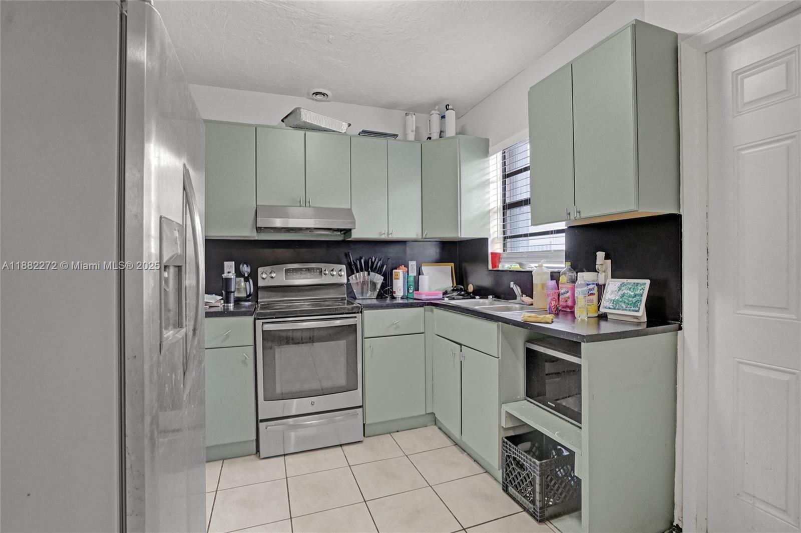 5606 Hayes Street, Unit 2 Hollywood, FL 33021 - Photo 13 of 20 a kitchen with cabinets and appliances