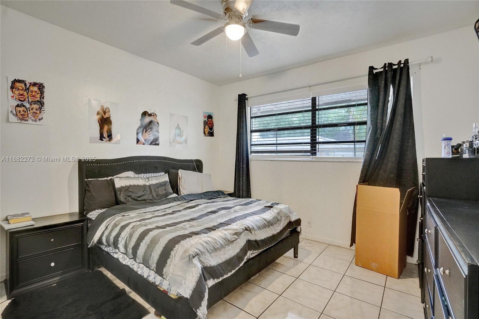 5606 Hayes Street, Unit 2 Hollywood, FL 33021 - Photo 5 of 20 a bedroom with a bed and a flat tv screen on dresser